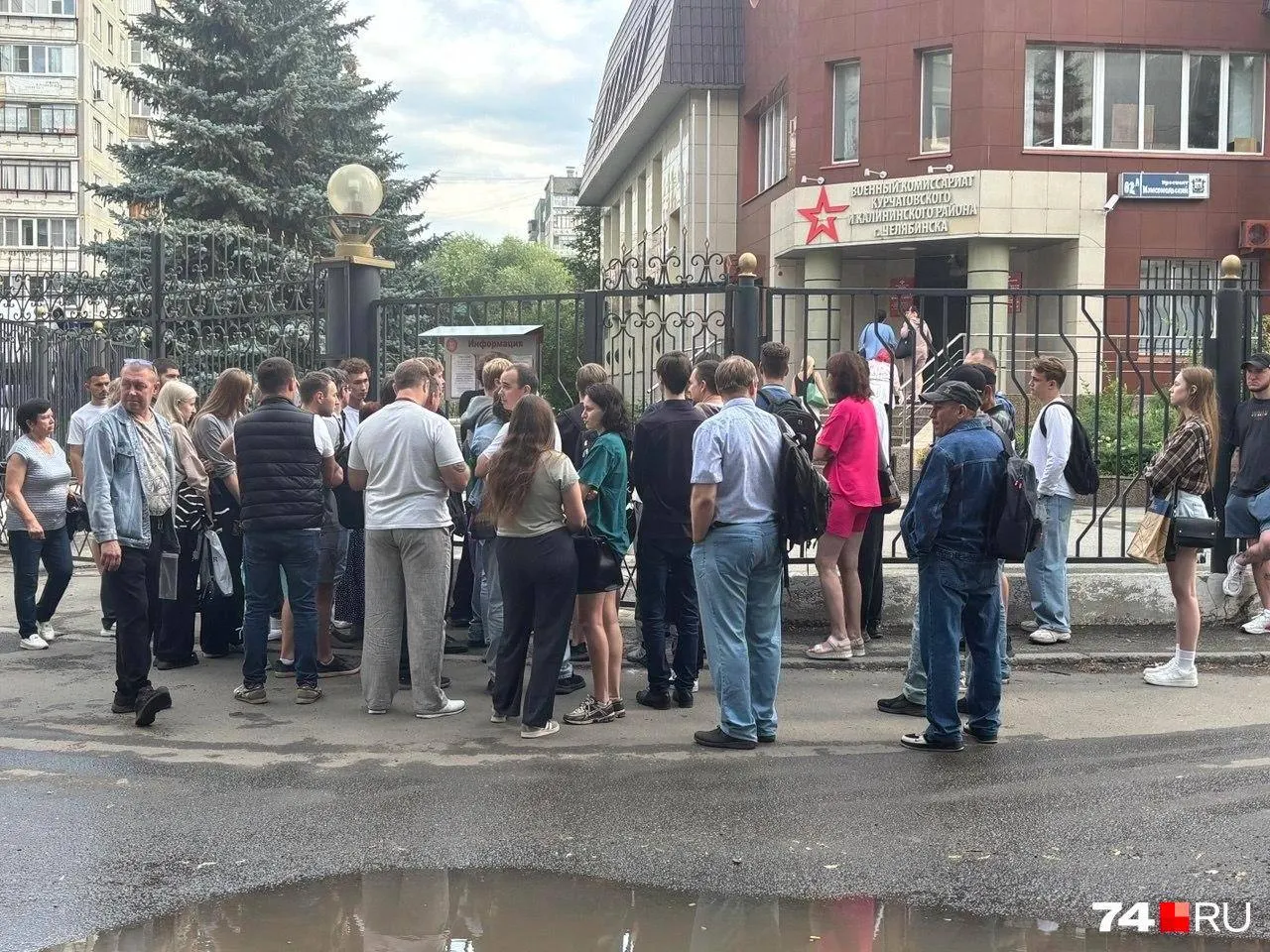 Жители Курчатовского и Калининского районов выстраиваются у входа, чтобы получить талон на оформление выплат по погибшему супругу; система электронной очереди не работает, списки составляют на бумаге.