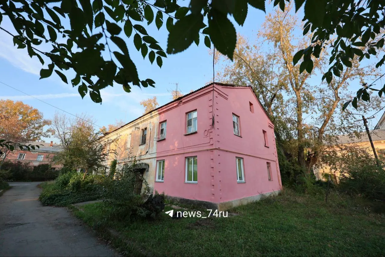 На Новороссийской улице в Челябинске проходят городские работы: вдоль дороги устанавливают елки, фасады старых домов частично окрасились в розовый оттенок, снимают ларёк Роспечати и наносят новую дорожную разметку.