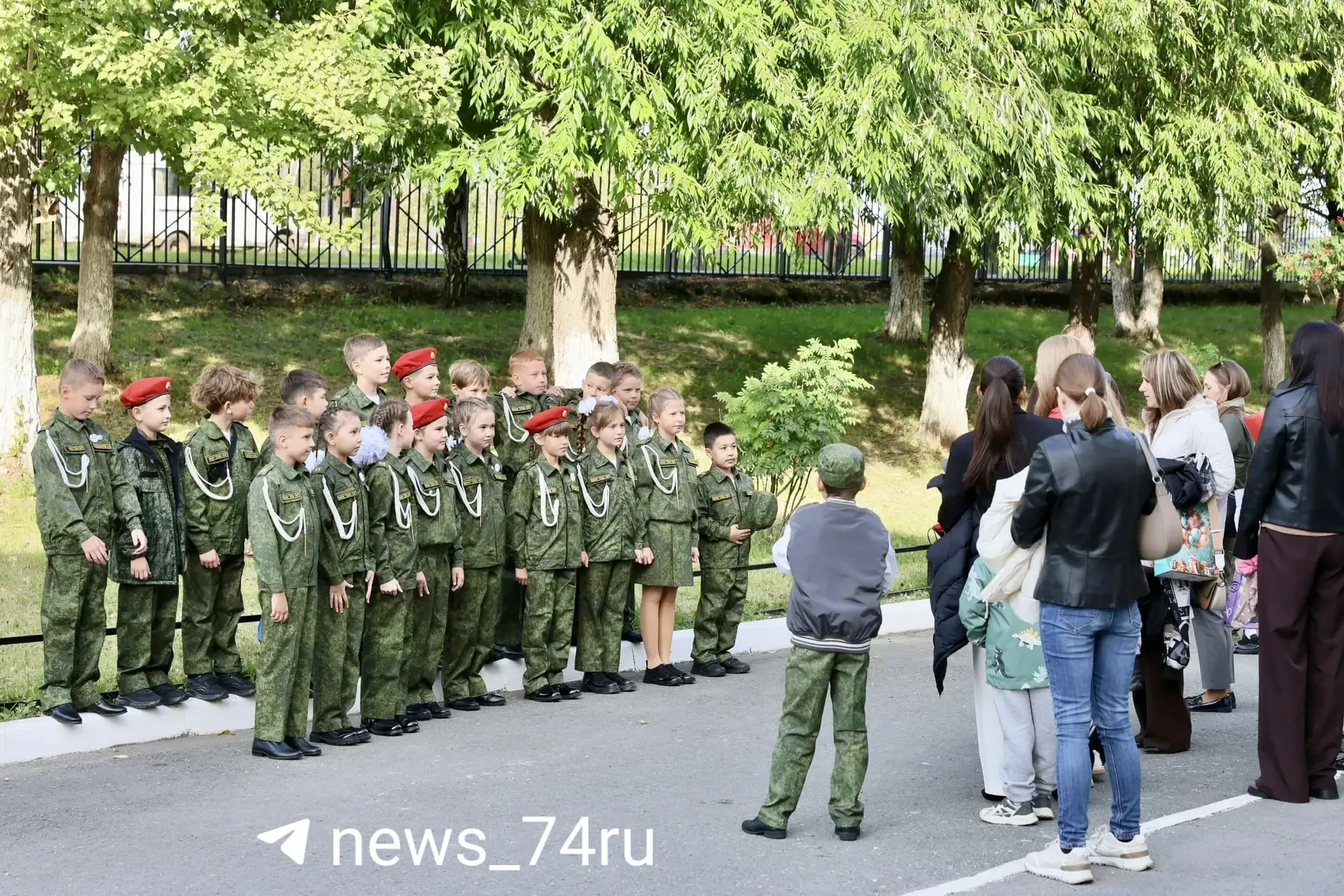 Во дворе школы №154 перед линейкой собираются ученики и родители, запланированной в спортзале.